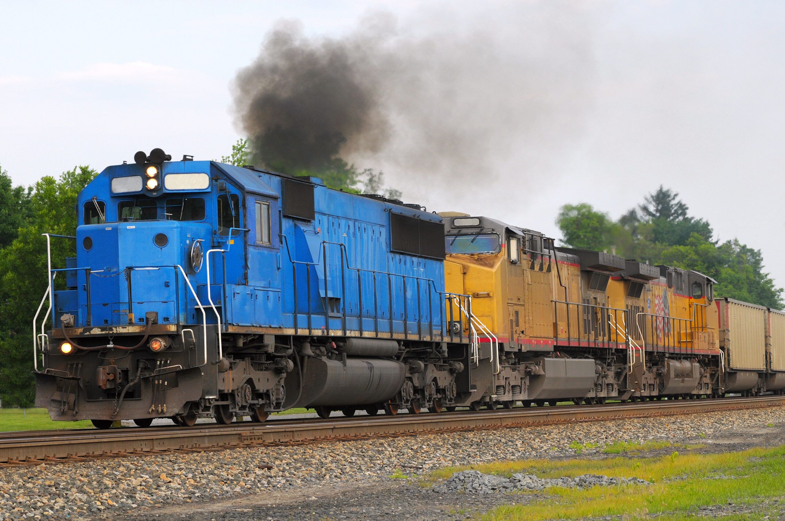 Blue and yellow freight train traveling on tracks