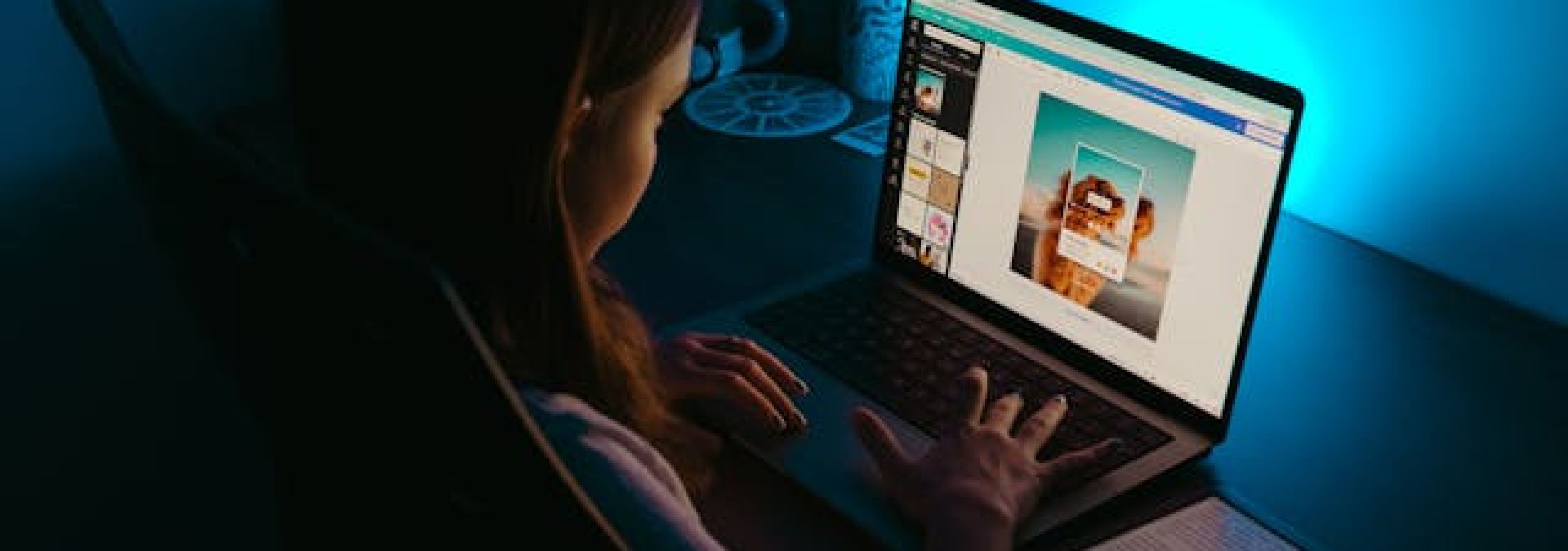 An adolescent girl using a laptop in a dark room