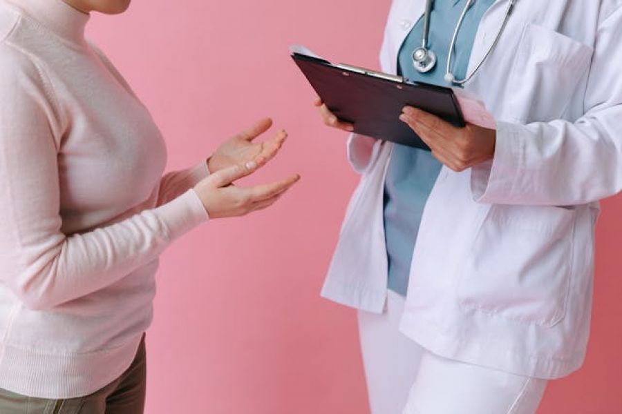 woman speaking to a doctor holding a tablet