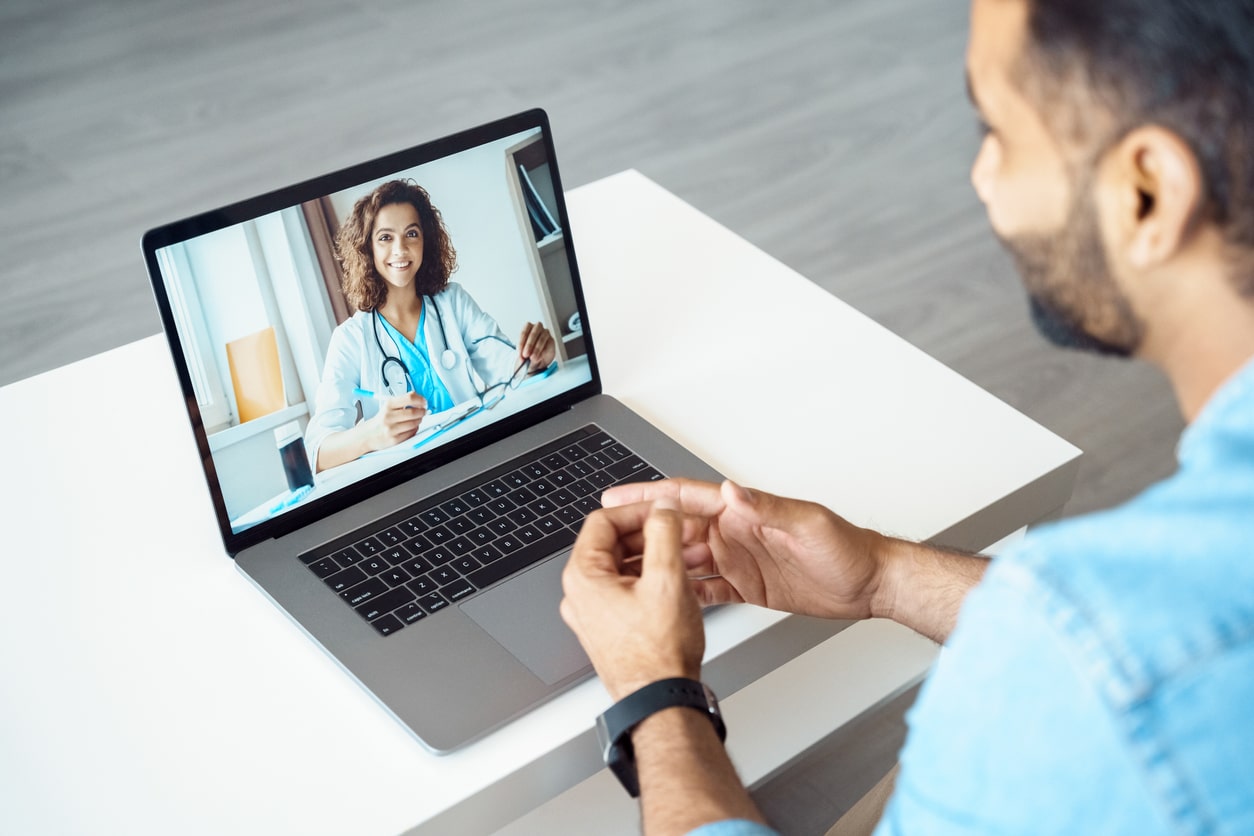 A male patient meets with his doctor over the computer for his telehealth appointment.