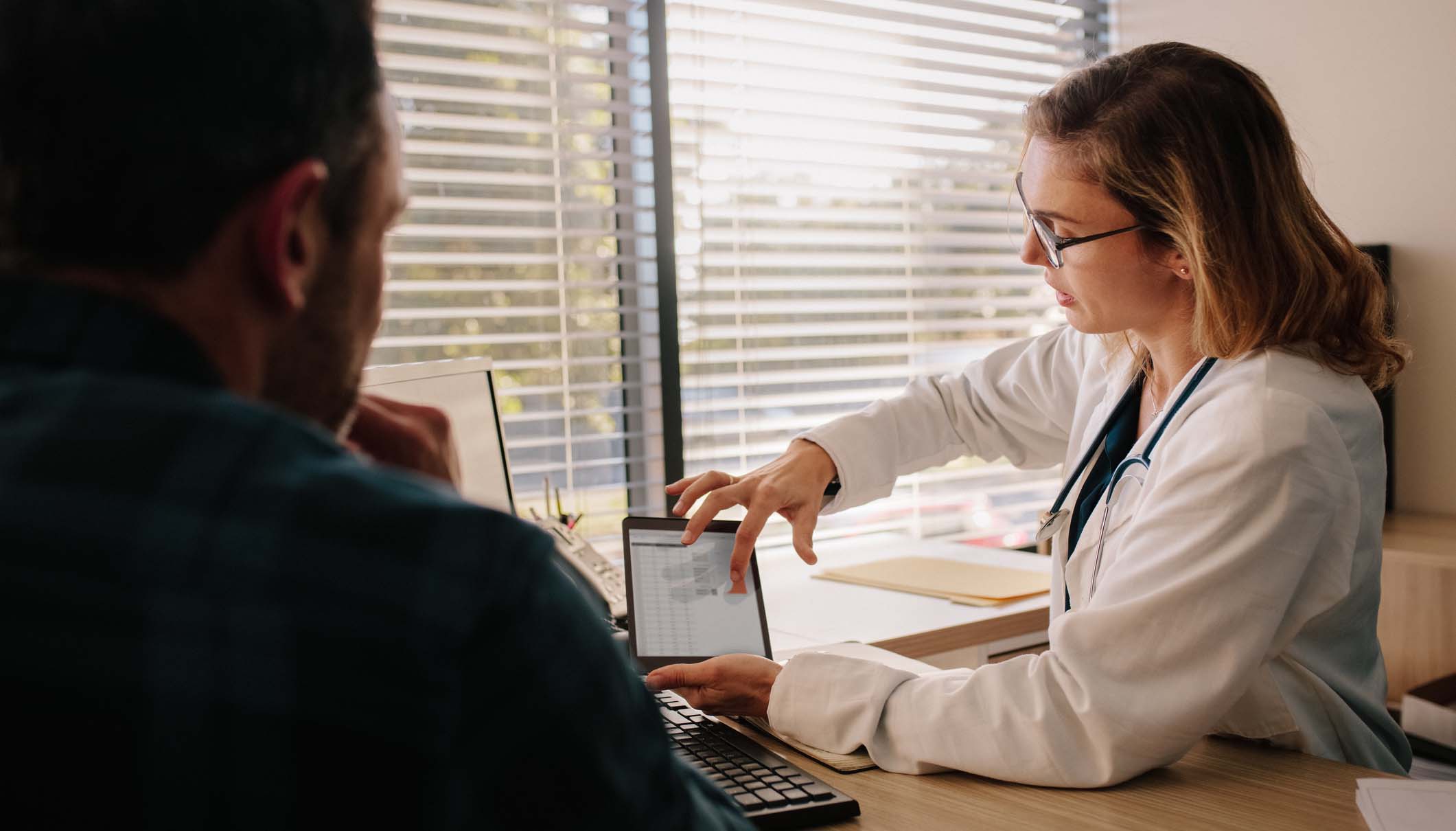 Female doctor looks over a tablet with her patient