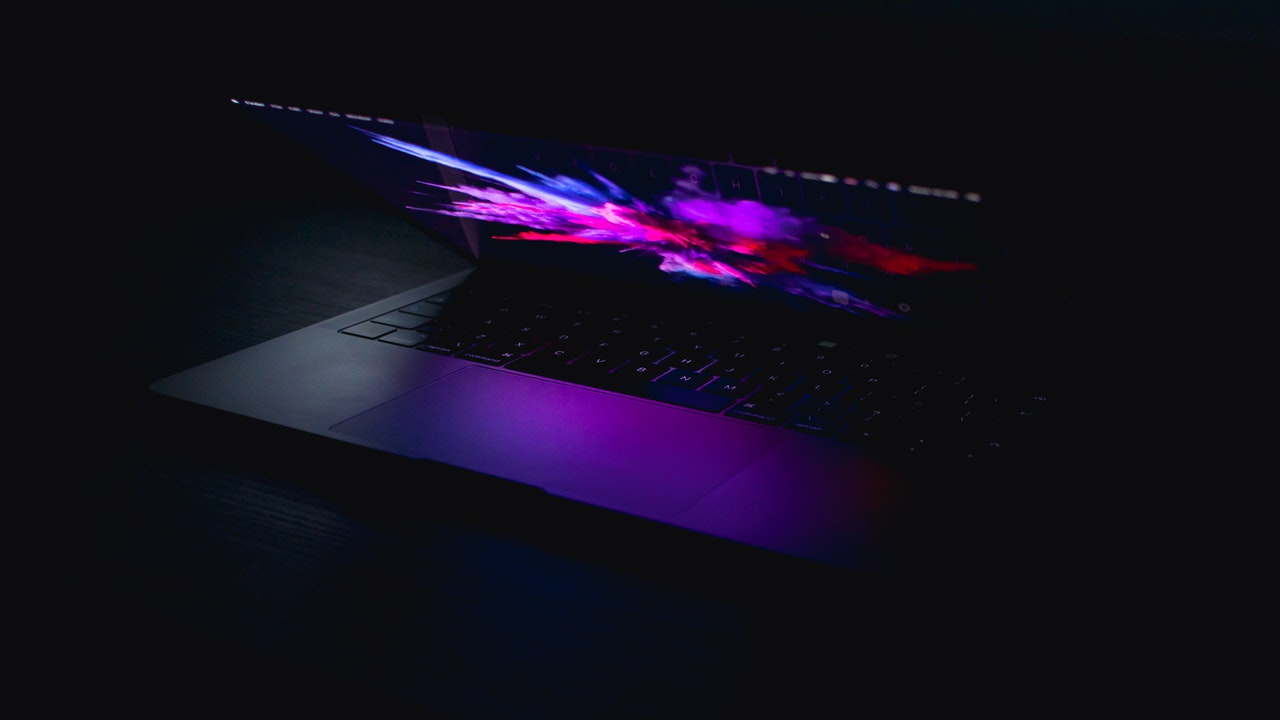 A closing laptop in a dark room