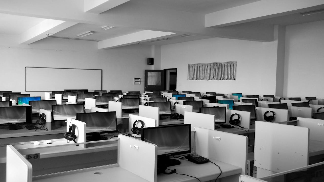 a room full of empty workstations at a calling center, perhaps made redundant by AI