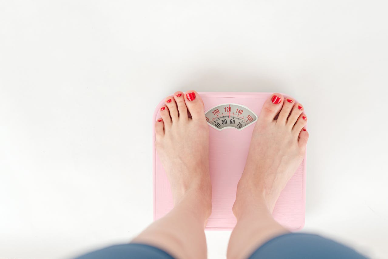 woman stepping on scale to see if her glp 1 supplement has been working